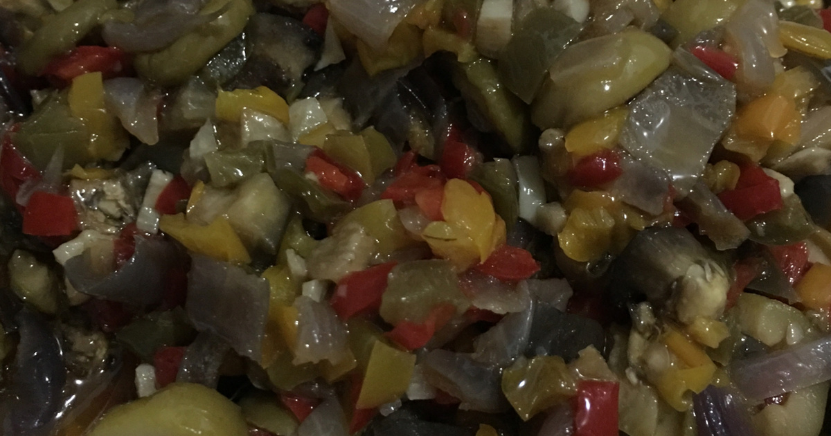 Close-up do antepasto de berinjela pronto, com pedaços de berinjela, pimentão e cebola bem temperados