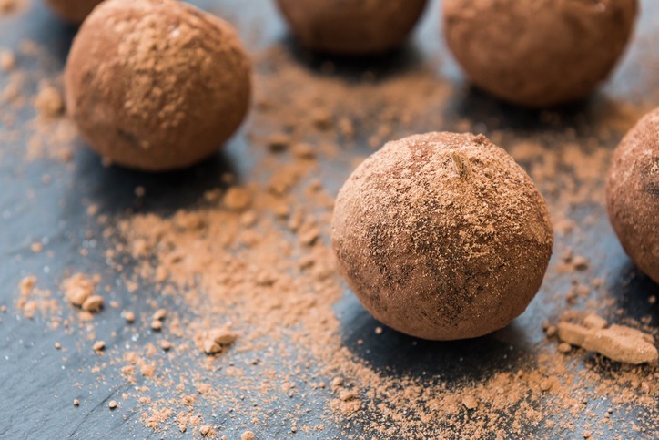 Close-up de brigadeiros de banana enrolados e passados no cacau em pó