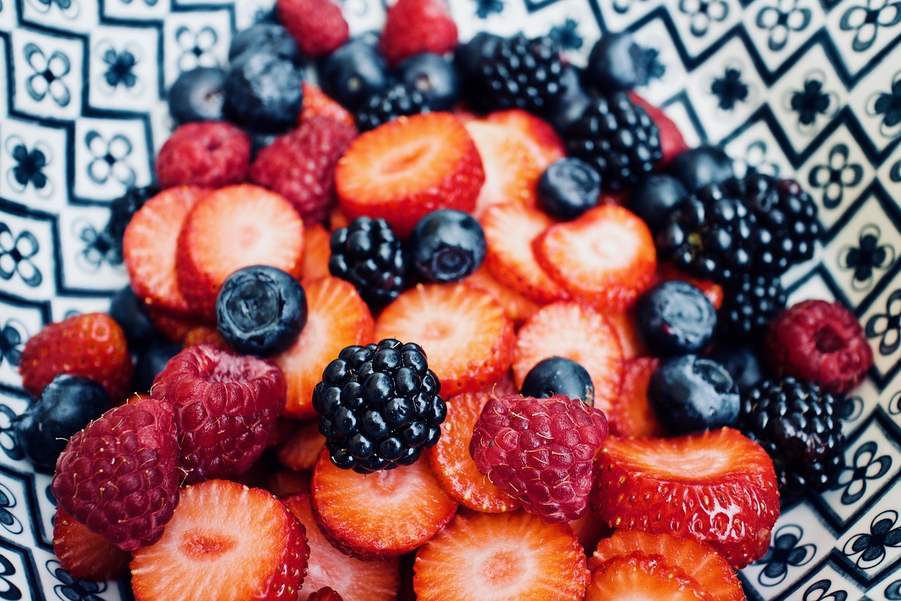 Morangos, framboesas, amoras e mirtilos frescos fatiados, as frutas vermelhas usadas na geleia de cobertura