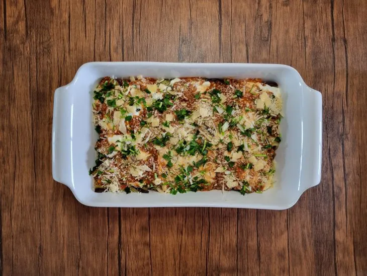 Lasanha de berinjela low carb pronta e gratinada numa travessa branca