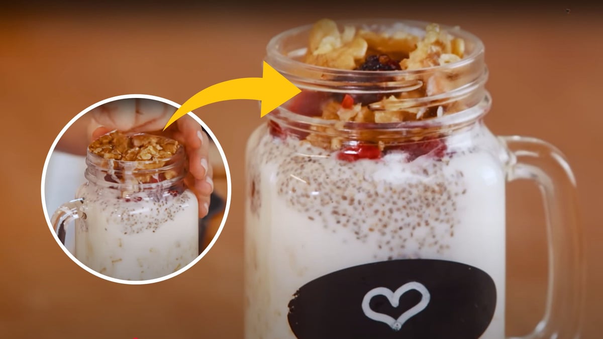Camada de granola e frutas sendo adicionada por cima do overnight oats num pote de vidro