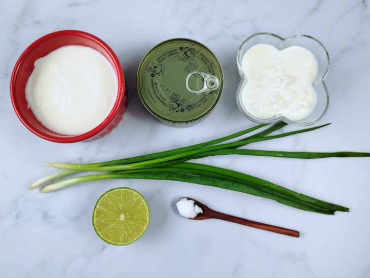 Ingredientes do patê de atum fit organizados sobre a bancada: iogurte, atum em lata, queijo cottage, cebolinha e limão