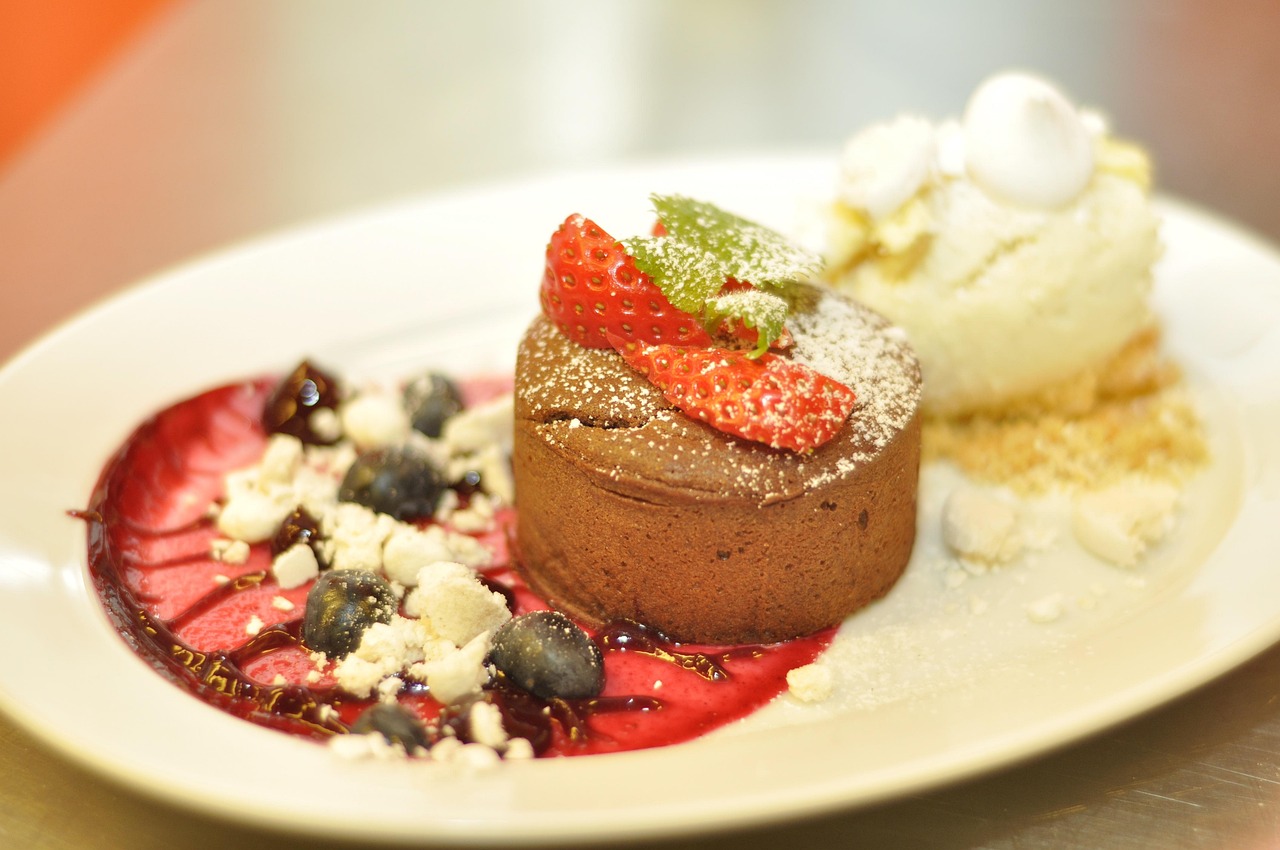 Petit gâteau de chocolate servido com sorvete de creme e calda de frutas vermelhas